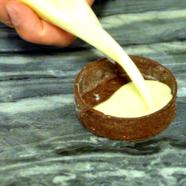 Chokladskalet fylls med vaniljpanna cotta för Choklad- och hasselnötstartelette av Johan Heibert Gastronomi för Söders gourmet